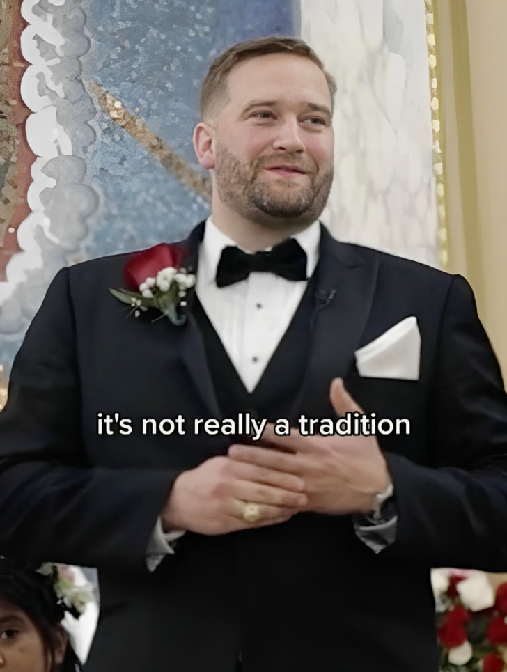 A groom at the altar wearing a black suit and bow tie.